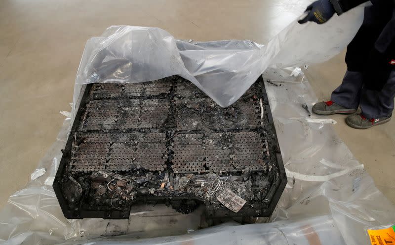 FILE PHOTO: A technician unpacks a completely burned Lithium-ion car battery before its dismantling by the German recycling firm Accurec in Krefeld