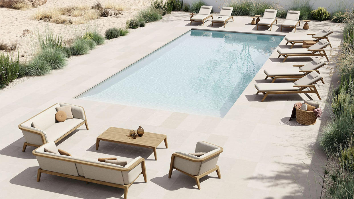  teak outdoor furniture surrounding a modern swimming pool 