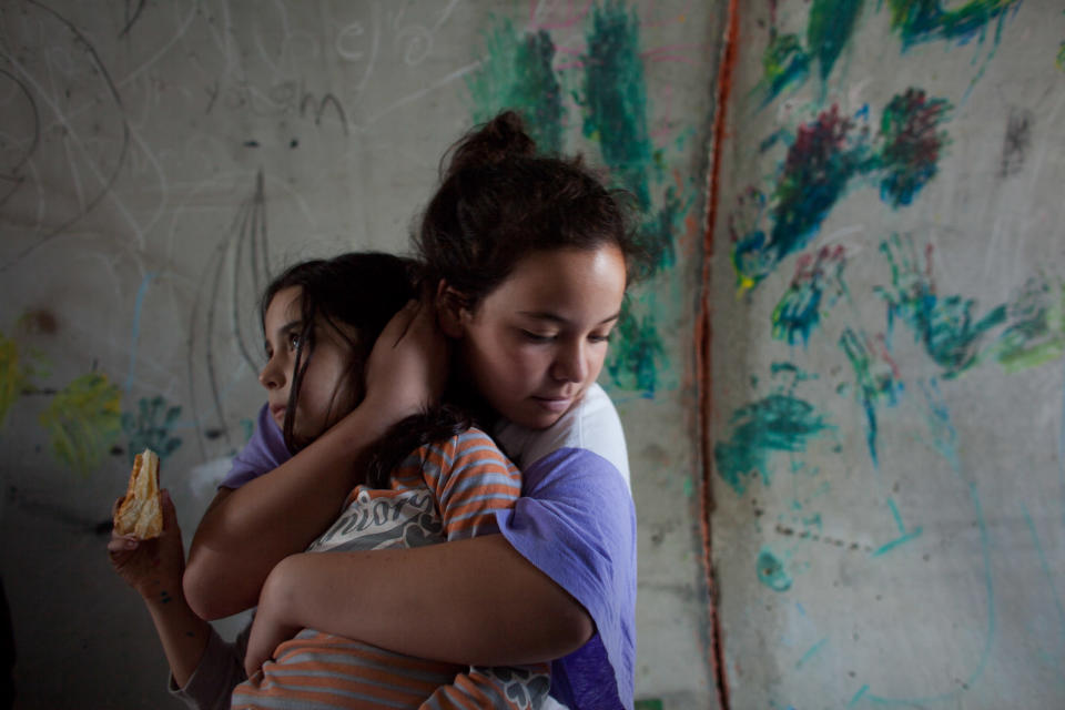 An Israeli girl holds her sister as they take cover in a large concrete pipe used as a bomb shelter during a rocket attack from the Gaza Strip on November 19, 2012 in Nitzan, Israel. (Photo by Uriel Sinai/Getty Images)