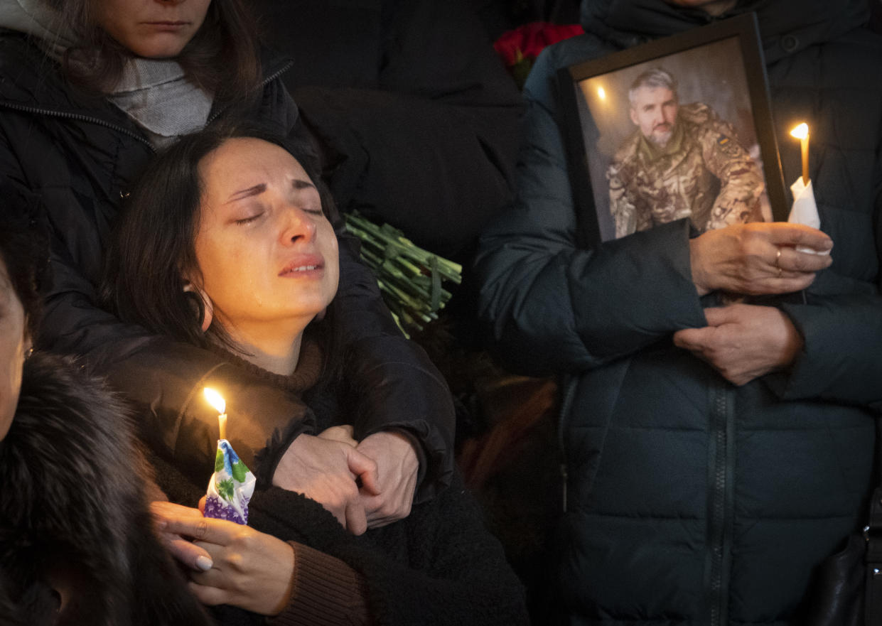 Relatives react at the coffin during the funeral ceremony of Volodymyr Yezhov killed in a battlefield with Russian forces at St. Volodymyr Cathedral in Kyiv, Ukraine, Tuesday, Dec. 27, 2022. Yezhov was a game designer in the development of the game Cossacks 2, one of the authors of the game S.T.A.L.K.E.R.: Clear Sky and also one of the most famous Ukrainian e-sportsmen — played StarCraft under the nickname Fresh. Since the Russian invasion, Volodymyr Yezhov went to the frontline and fought as part of the volunteer squadron. (AP Photo/Efrem Lukatsky)