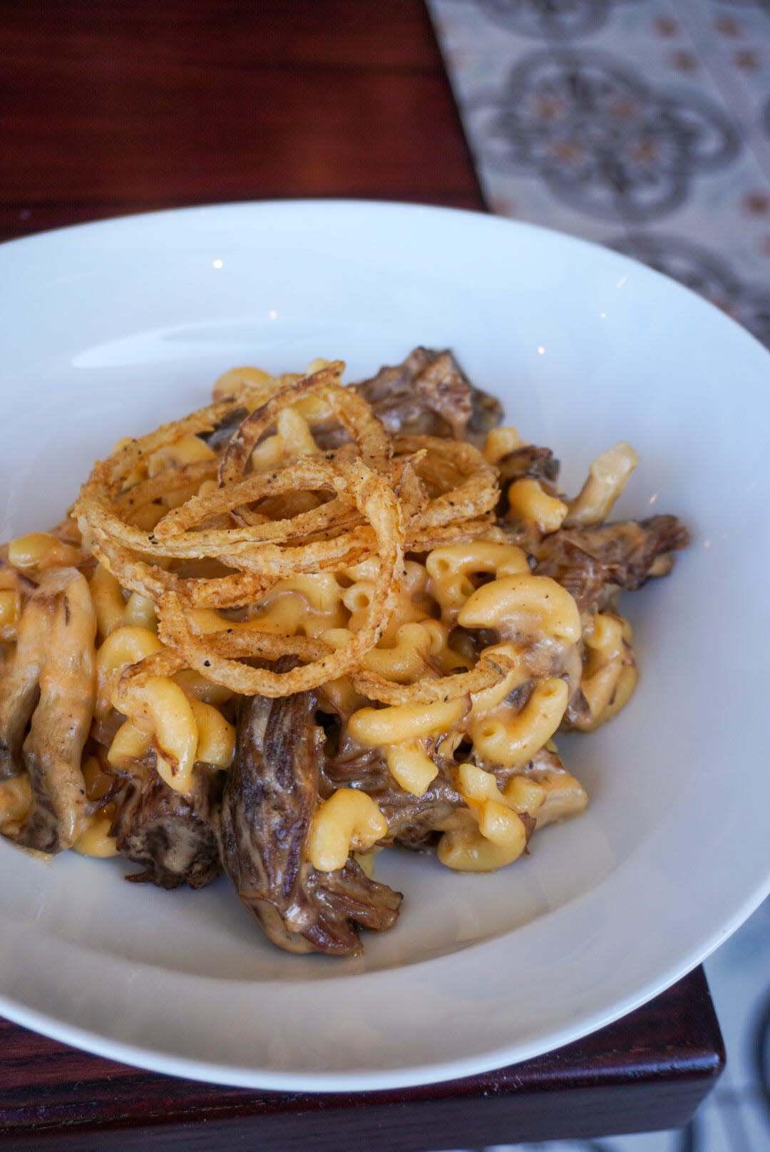 The Short Rib Mac and Cheese at Proper Grit in downtown West Palm Beach features braised short rib and mushrooms topped with crispy fried onions on top.