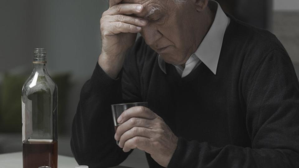 Un hombre deprimido bebiendo alcohol