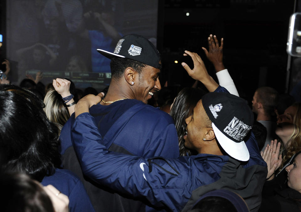 Connecticut men's basketball players DeAndre Daniels, left, and Tor Watts celebrate as they watch television coverage of the final seconds the UConn women's team's 79-58 win over Notre Dame in the NCAA women's college basketball tournament title game, Tuesday, April 8, 2014, in Storrs, Conn. (AP Photo/Jessica Hill)