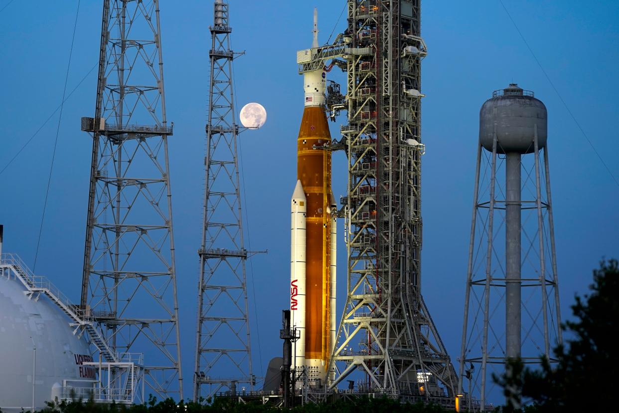 The moon sets behind the NASA Artemis rocket at Kennedy Space Center on June 15.