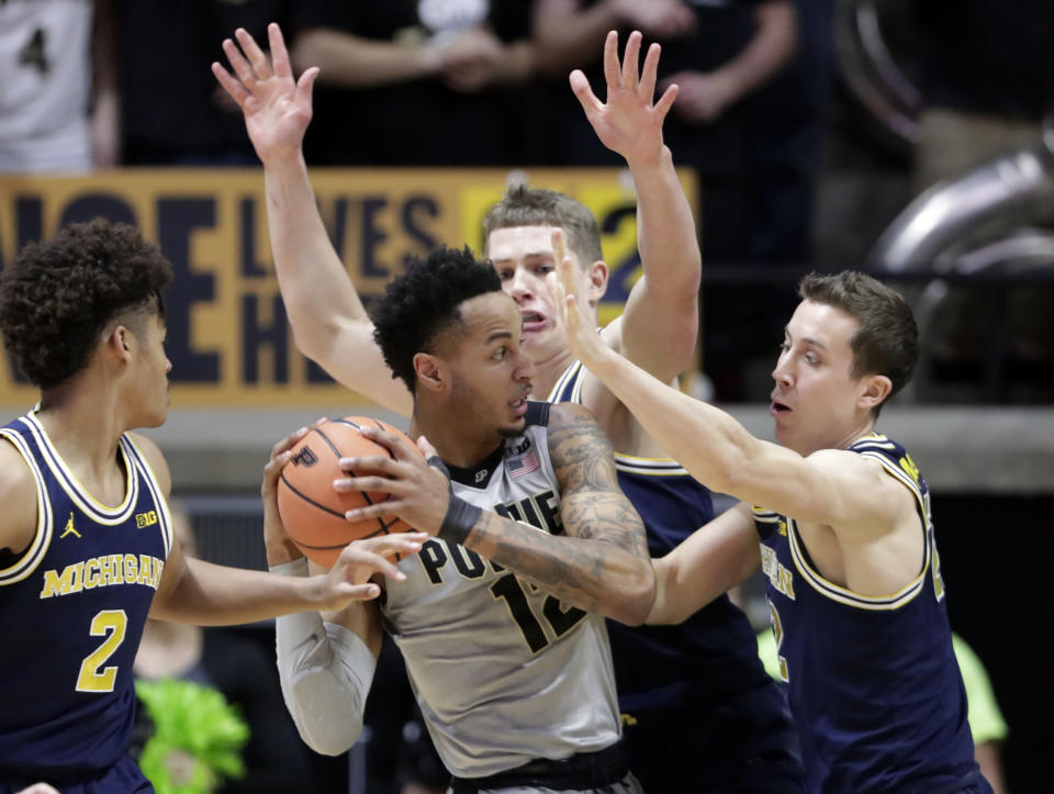 Purdue forward Vincent Edwards (12) is stopped by Michigan guard Duncan Robinson (22) and forward Moritz Wagner (13) during the first half of an NCAA college basketball game in West Lafayette, Ind., Thursday, Jan. 25, 2018. (AP Photo/Michael Conroy)