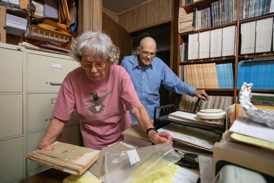 Tom Heindel watches as his wife, Joanne Heindel, returns a vintage book into its protective bag.