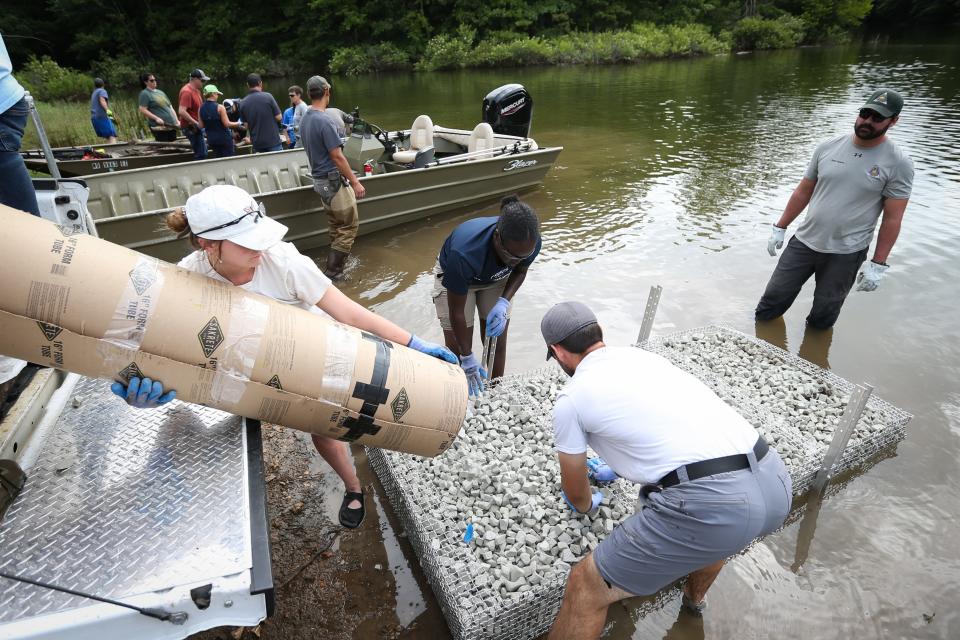 Missouri Department of Conservation, City Utilities and Watershed Committee of the Ozarks staff layer recycled glass foam aggregate onto an aluminum structure, which still serve as the base of a floating wetland, at Fellows Lake on Monday, July 1, 2024.