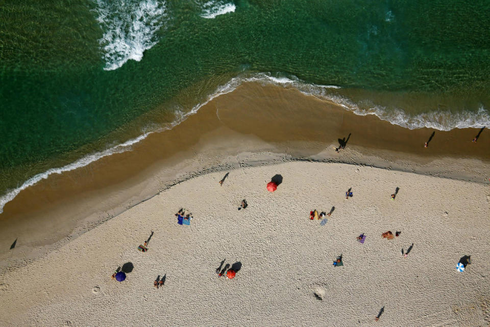 People enjoy the sun at beach in Rio de Janeiro