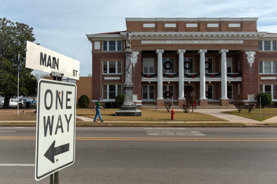 A pedestrian walks by a Confederate monument outside the Clarke County Courthouse in Quitman on Dec. 20, 2023.