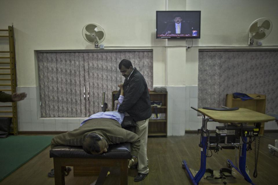 In this Friday, Jan. 17, 2014, photo, a patient at the Armed Forces Institute for Rehabilitation Medicine, receives a phsyotherapy session, in Rawalpindi, Pakistan. Soldiers of the Pakistani security forces learn exactly these types of scenarios to deal with the improvised bombs that have become increasingly popular in wars like Iraq, Afghanistan and the insurgency that Pakistan's forces are fighting in the northwestern tribal areas. (AP Photo/Muhammed Muheisen)