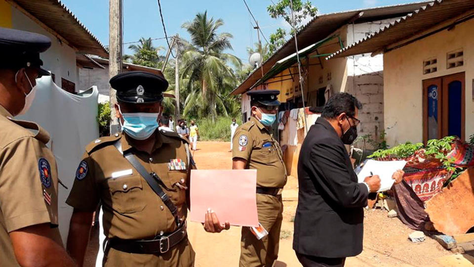 Sri Lankan magistrate Wasantha Ramanayake, right and police officers inspect outside a house where a nine year old girl was canned to death in Delgoda. Source: AP