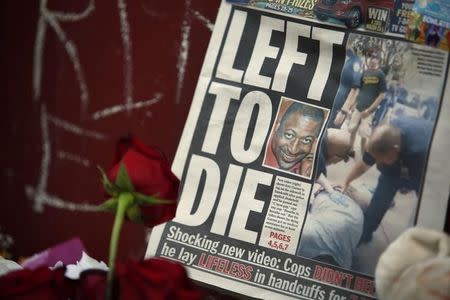A picture of Eric Garner is seen on a newspaper at his memorial in Staten Island, New York, July 21, 2014. REUTERS/Eduardo Munoz