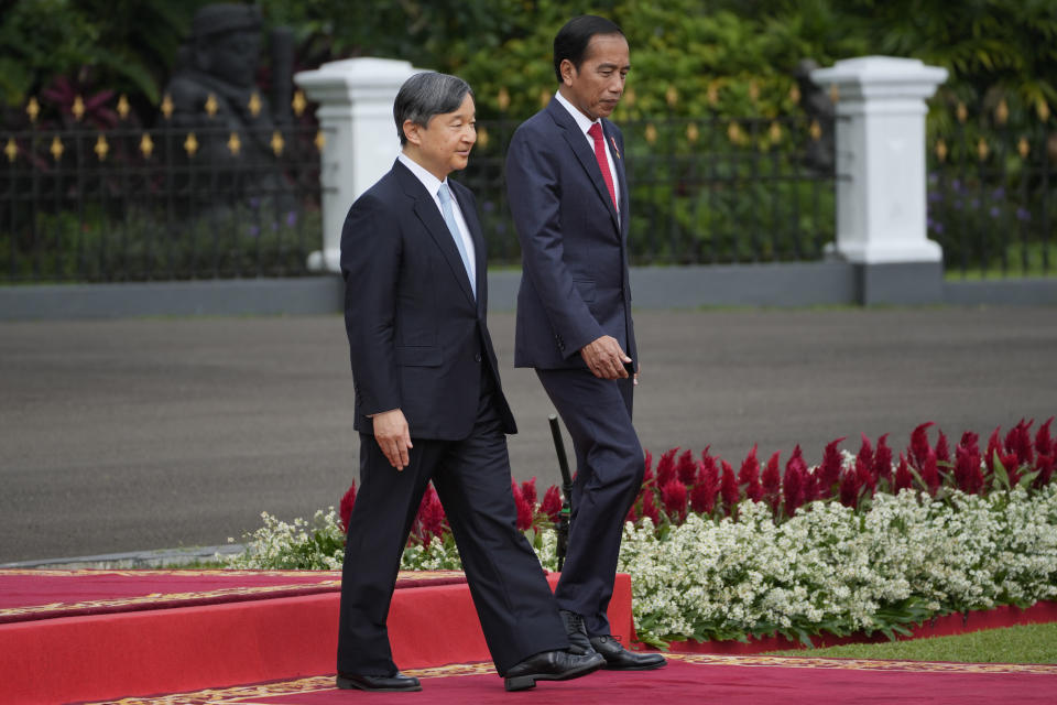 Japanese Emperor Naruhito, left, accompanied by Indonesian President Joko Widodo, right, inspects an honor guard upon his arrival at the Presidential Palace in Bogor, West Java, Indonesia, Monday, June 19, 2023. The Japanese royals are on a weeklong visit in the country, their first official friendship trip abroad since ascending the Chrysanthemum Throne four years ago.(AP Photo/Achmad Ibrahim, Pool)