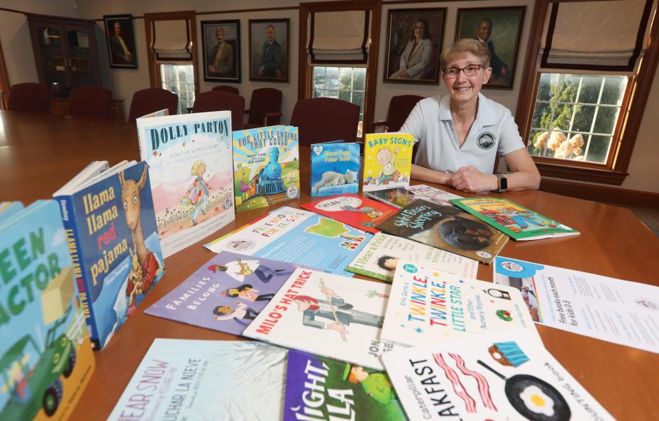 Becky Hill, treasurer of the Muskingum County Literacy Council, with some of the books distributed by the council. The MCLC was a recent benefactor of 100 Women Who Care, and Hill said the funding will help get more than 2000 books to area children.