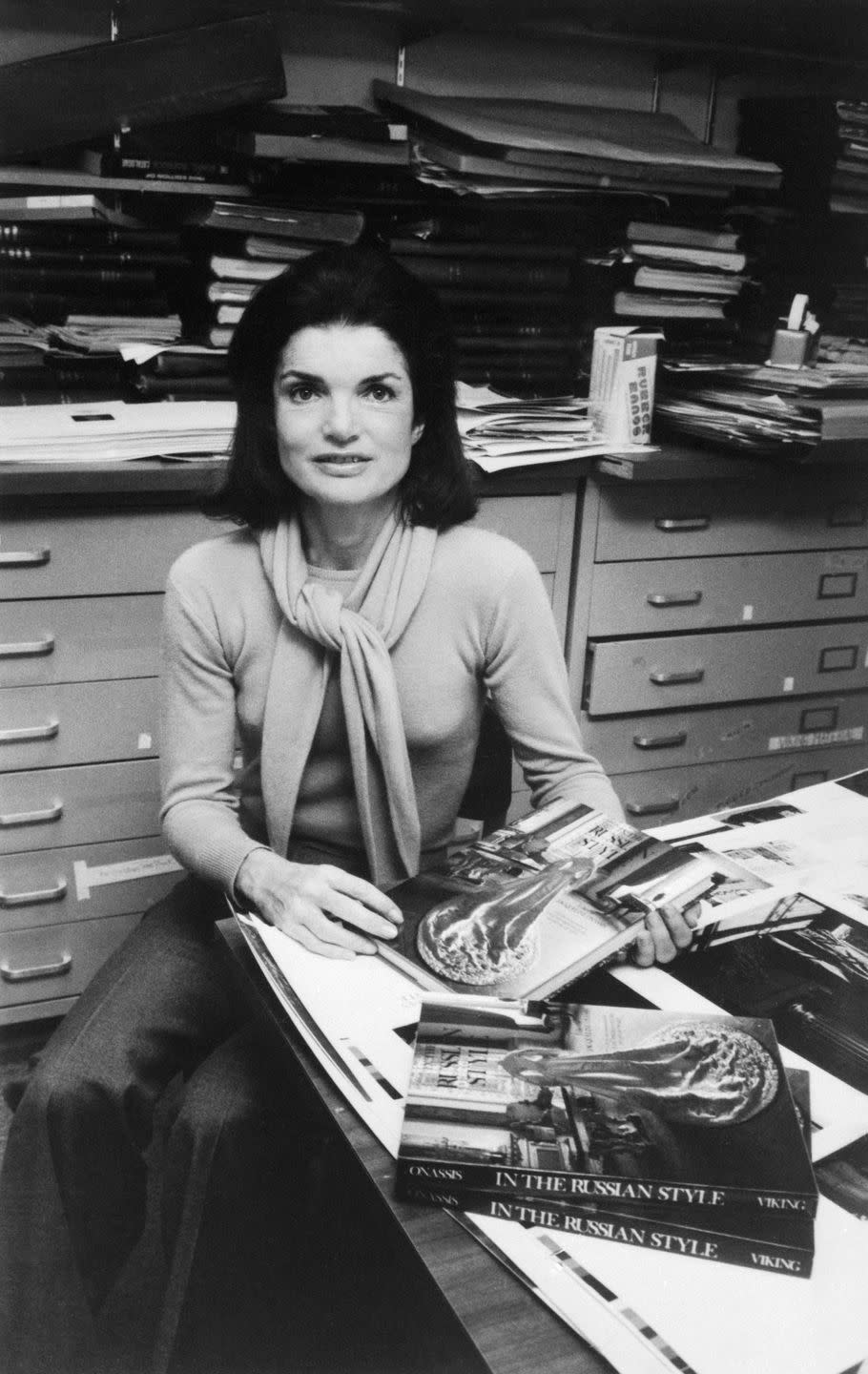 <p>Here, Jackie is photographed in her office at Viking Press, where she wrote and edited her first book <em>In the Russian Style</em>. She looks the part of a New York editor with a matching sweater set and flared tweed pants. <br></p>