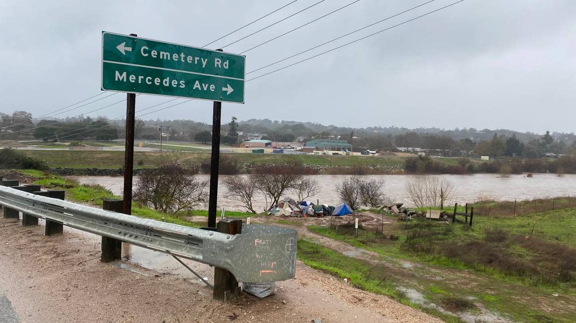 The Salinas River flows beneath the Highway 41 bridge beside a homeless camp on Jan. 9, 2023.