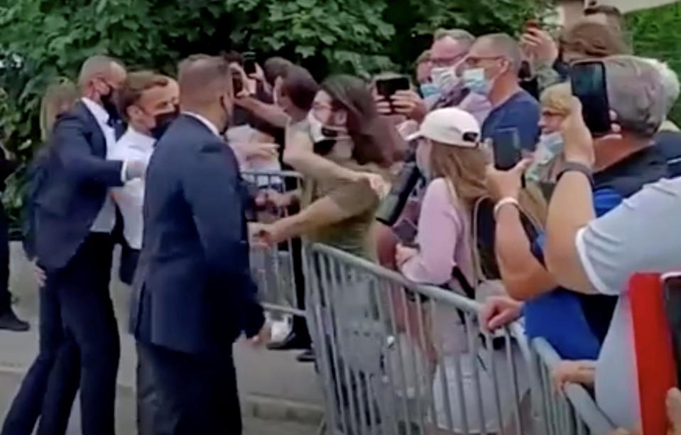 French President Emmanuel Macron gets slapped by a member of the public during a visit in Tain-L'Hermitage, France, in this still image taken from video on June 8, 2021.  / Credit: BFMTV/ReutersTV