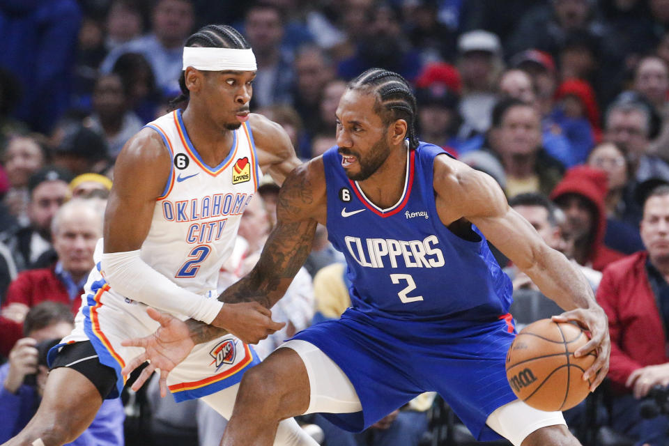 Los Angeles Clippers forward Kawhi Leonard, right, is defended by Oklahoma City Thunder guard Shai Gilgeous-Alexander during the first half of an NBA basketball game Tuesday, March 21, 2023, in Los Angeles. (AP Photo/Ringo H.W. Chiu)