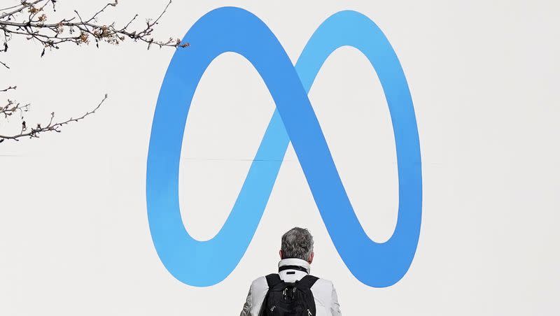 A person stands in front of a Meta sign outside of the company’s headquarters in Menlo Park, Calif., Tuesday, March 7, 2023. Canadian authorities are asking Facebook to reverse a ban on news content in the face of wildfires in the country.