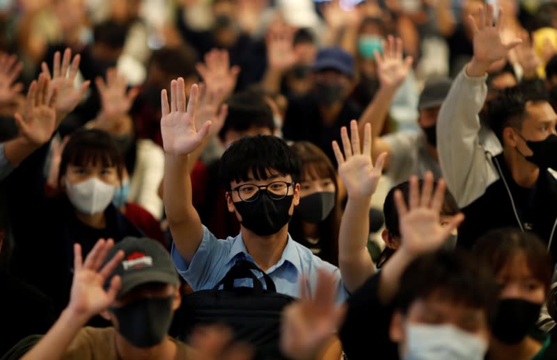 Protesters hold up their hands during an anti-government protest at Yoho Mall in Yuen Long, Hong Kong