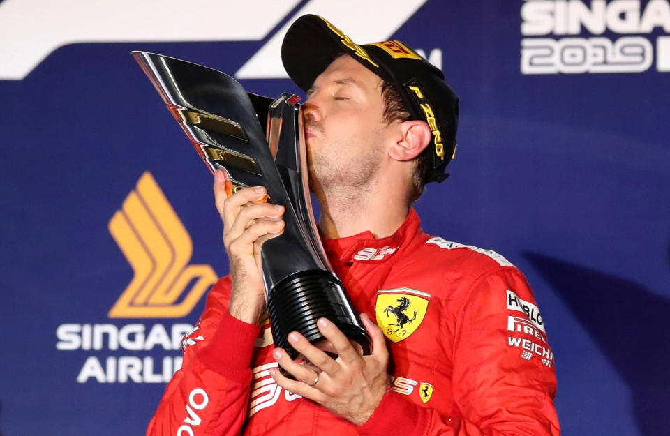 Formula One F1 - Singapore Grand Prix - Marina Bay Street Circuit, Singapore - September 22, 2019  Ferrari's Sebastian Vettel kisses the trophy as he celebrates after winning the race  REUTERS/Feline Lim