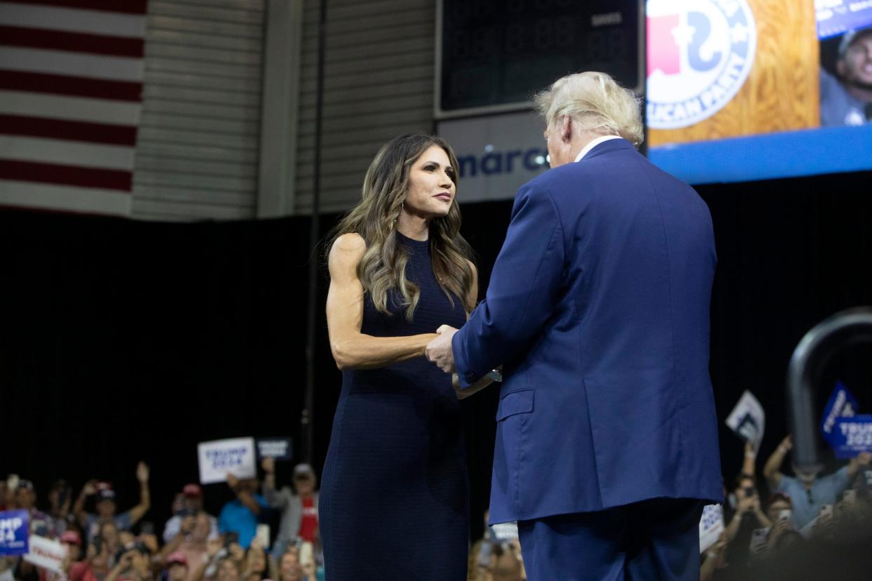 Kristi Noem greets Donald Trump at a political rally