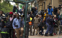 Members of the media and police officers await the arrival of Oscar Pistorius at the high court for his murder trial in Pretoria, South Africa, Tuesday, March 11, 2014. Pistorius is charged with murder for the shooting death of his girlfriend, Reeva Steenkamp, on Valentines Day in 2013. (AP Photo/Themba Hadebe)