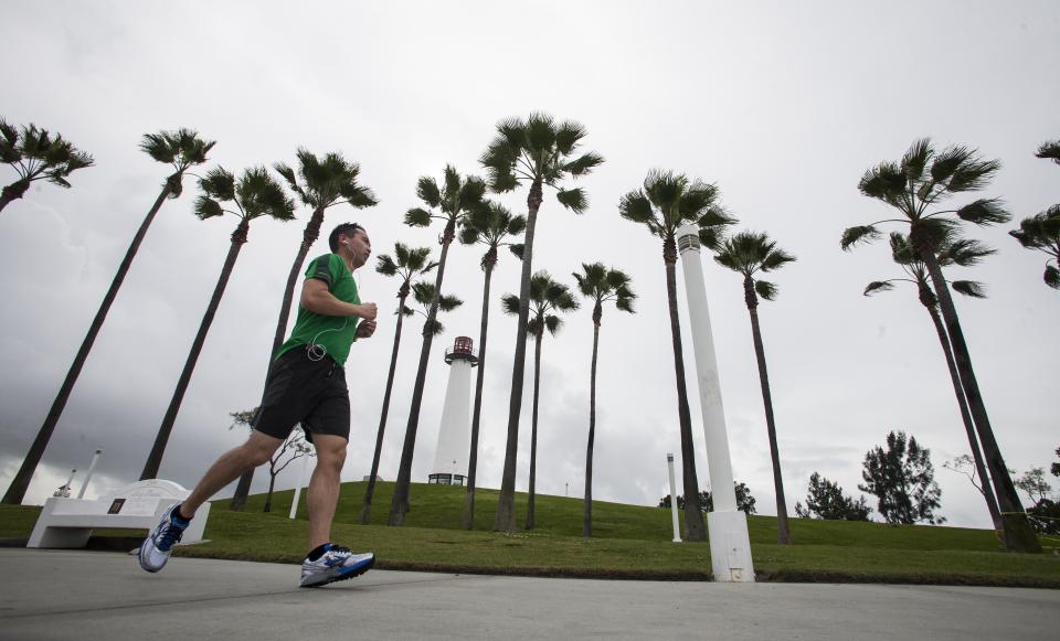 A man runs through Shoreline Aquatic Park in Long Beach, Calif. on Saturday, March 1, 2014. Earlier, a powerful Pacific storm hit the area, but did not put a major dent in a drought that is among the worst in recent California history. (AP Photo/Ringo H.W. Chiu)