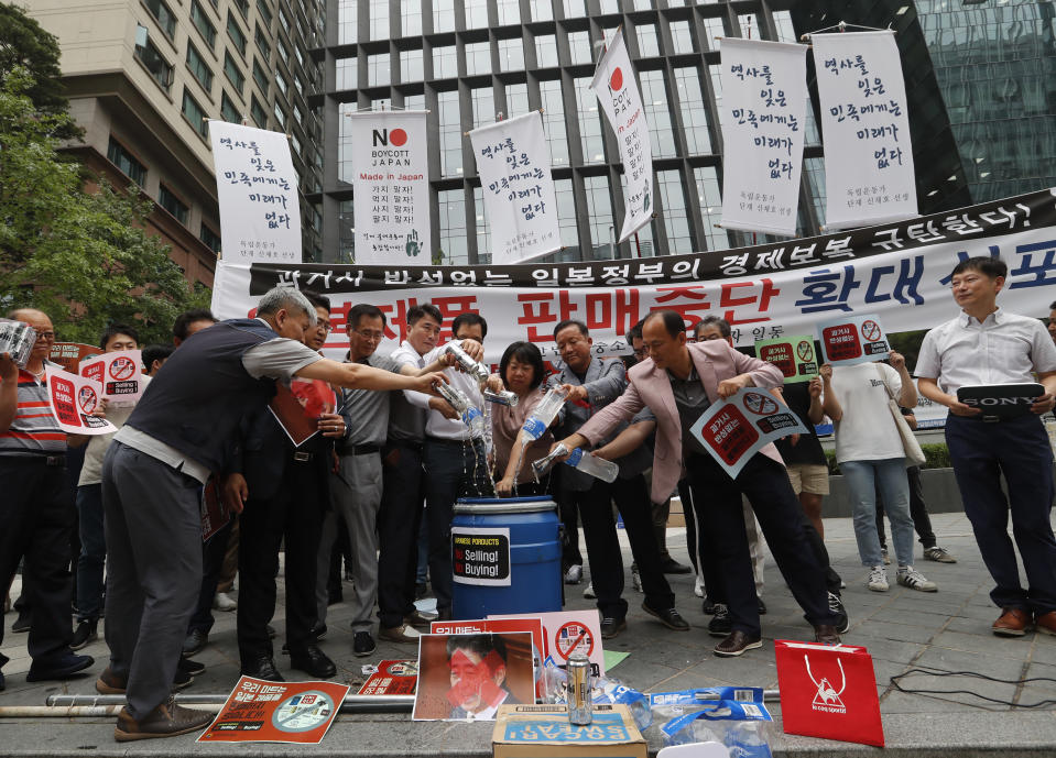 South Korean small and medium-sized business owners pour beers and drinking waters from Japanese brands into a trash can during a rally calling for a boycott of Japanese products in front of the Japanese embassy in Seoul, South Korea, Monday, July 15, 2019. South Korea and Japan last Friday, July 12, failed to immediately resolve their dispute over Japanese export restrictions that could hurt South Korean technology companies, as Seoul called for an investigation by the United Nations or another international body. The signs read: "Our supermarket does not sell Japanese products." (AP Photo/Ahn Young-joon)