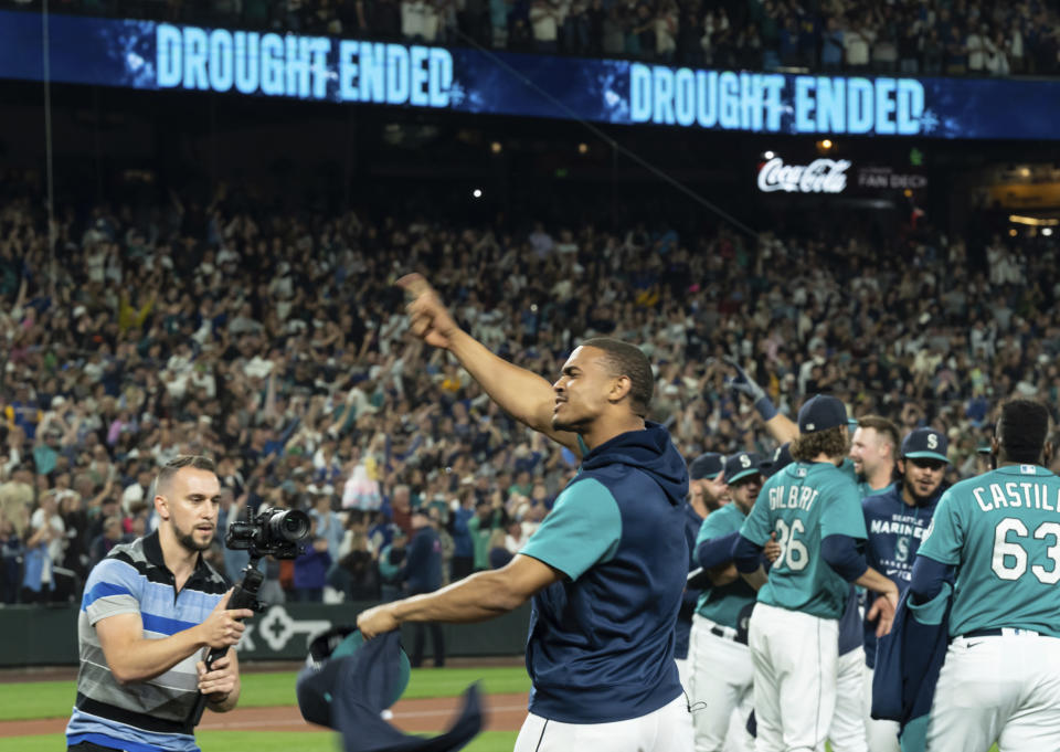 Seattle Mariners' Julio Rodriguez celebrates on the field after the team's baseball game against the Oakland Athletics, Friday, Sept. 30, 2022, in Seattle. The Mariners won 2-1 to clinch a spot in the playoffs. (AP Photo/Stephen Brashear)