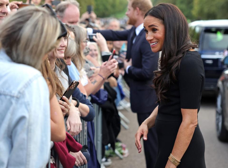 WINDSOR, ENGLAND - SEPTEMBER 10: Meghan Duchess of Sussex speaks with well-wishers at Windsor Castle on September 10, 2022 in Windsor, England. Crowds have gathered and tributes left at the gates of Windsor Castle to Queen Elizabeth II, who died at Balmoral Castle on 8 September, 2022. (Photo by Chris Jackson - WPA Pool/Getty Images)