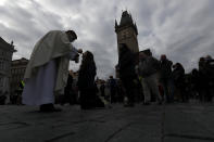 Dozens of worshippers attend a mass celebrated at Old Town Square in Prague, Czech Republic, Sunday, Oct. 18, 2020. As Czech Republic battles new spike of coronavirus infections newly adopted COVID-19 restrictive measures limit indoor gatherings to six people or less. (AP Photo/Petr David Josek)