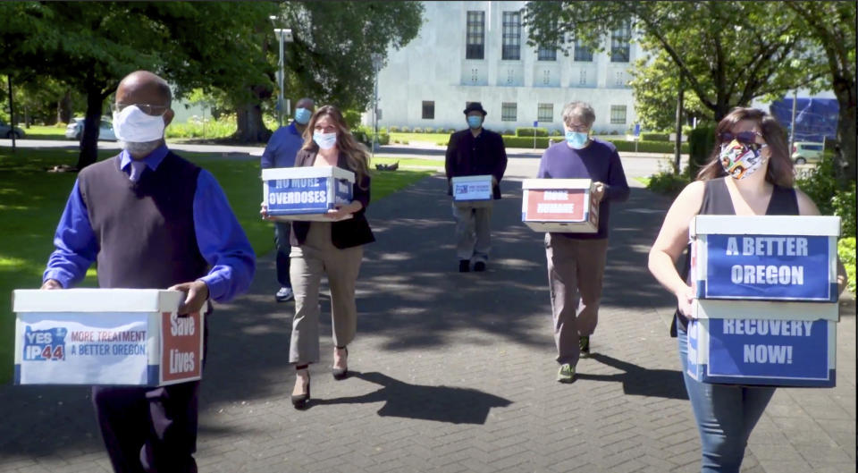 FILE - This June 26, 2020 file photo from video provided by the Yes on Measure 110 Campaign shows volunteers delivering boxes containing signed petitions in favor of the measure to the Oregon Secretary of State's office in Salem. The measure said the U.S., possession of small amounts of heroin, cocaine, LSD and other hard drugs would be decriminalized in Oregon. Election returns show the measure passed on Election Day, Tuesday, Nov. 3. (Yes on Measure 110 Campaign via AP, File)