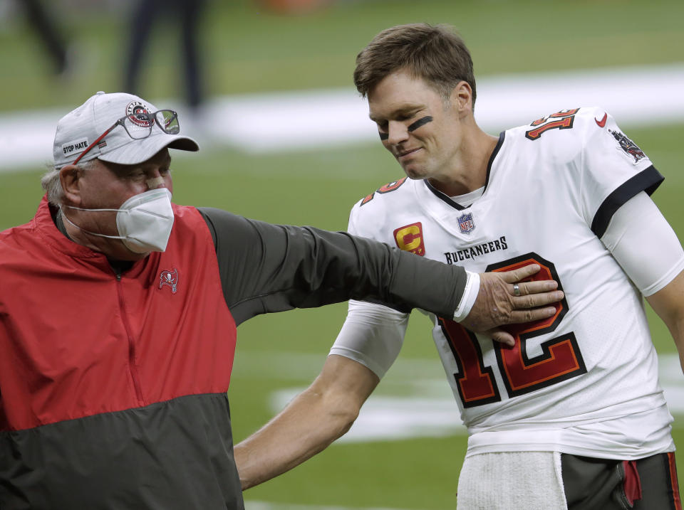 FILE - In this Jan. 17, 2021, file photo, Tampa Bay Buccaneers coach Bruce Arians, left, speaks with quarterback Tom Brady before the team's NFL divisional round playoff football game against the New Orleans Saints in New Orleans. Both Andy Reid and Arians are considered players’ coaches, though they do it in different ways. It's a quality that’s helped them reach the Super Bowl. (AP Photo/Brett Duke, File)