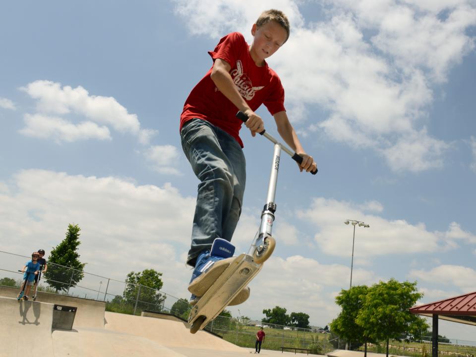 A boy riding a razor scooter.