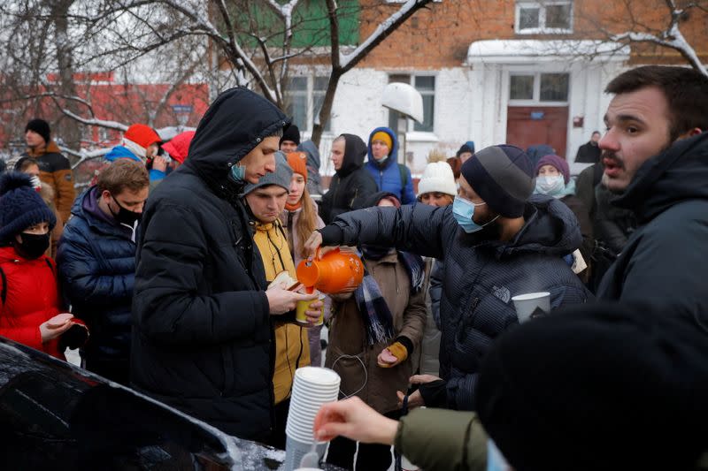 People, including supporters of Alexei Navalny, gather outside a police station where the opposition leader is being held following his detention, in Khimki