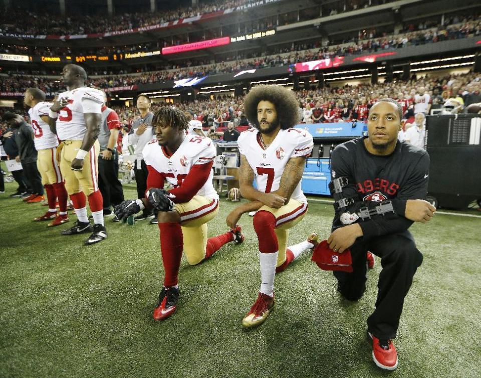 Colin Kaepernick (7) and 49ers linebacker Eli Harold (58) kneel during the playing of the national anthem before a game last season (AP)