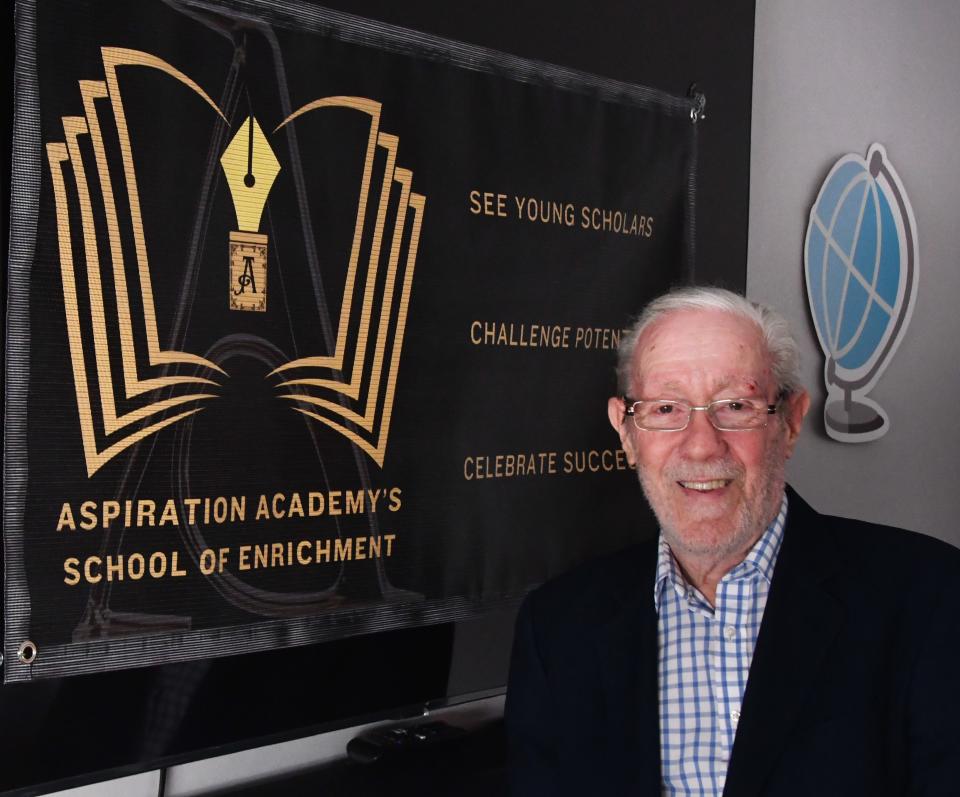 Bob Barnes stands by the banner Aspiration Academy’s School of Enrichment, an after-school program set to begin in 2025 at Cambridge Elementary School in Cocoa.