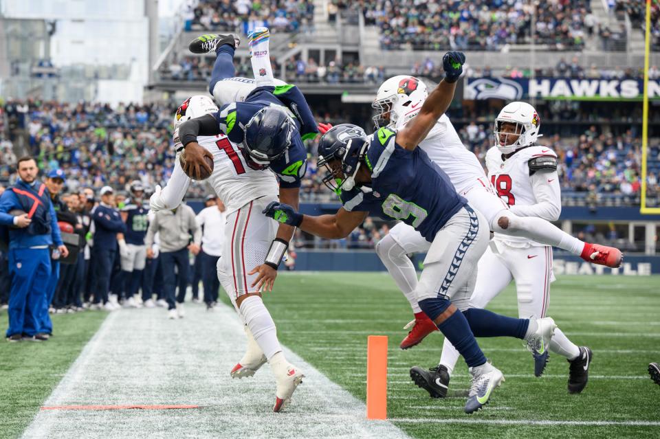 Seattle Seahawks quarterback Geno Smith (7) jumps over Arizona Cardinals linebacker Josh Woods (10) to get a first down.
