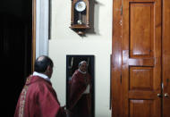 Rev. Mario Carminati is reflected in a mirror before celebrating Mass inside the Santissima Redentore church in Seriate, near Bergamo, Italy, Sunday, Sept. 27, 2020. If there is anything the Rev. Carminati and the traumatized residents of Italy’s Bergamo province remember about the worst days of the coronavirus outbreak, it’s the wail of ambulance sirens piercing the silence of lockdown. (AP Photo/Antonio Calanni)