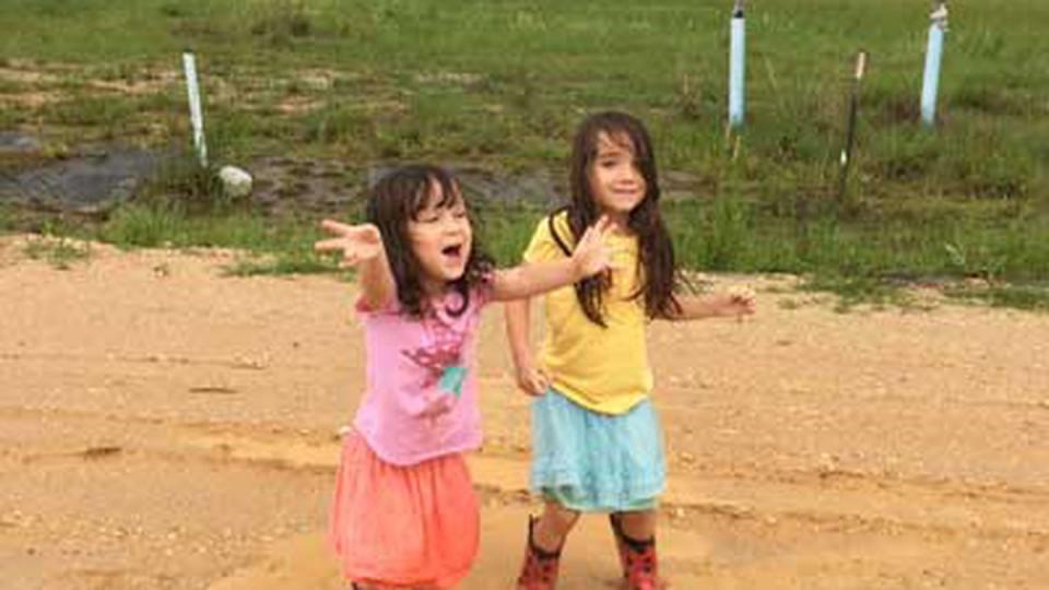 Rori and Katalina Rathbun, playing in the rain, April 2016. “I missed being a parent with him,” writes Andrea Rathbun of her husband’s deployments. Photo courtesy of the author.