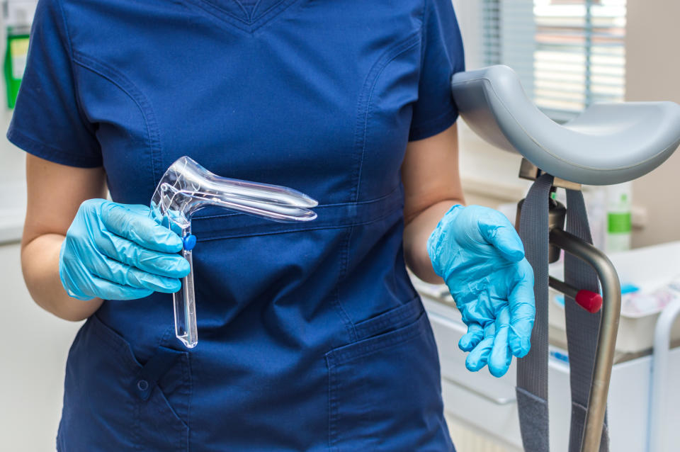 A doctor holding onto clamps for a pap smear