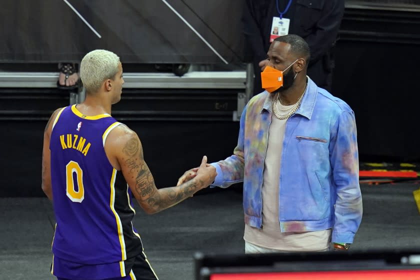 Los Angeles Lakers forward LeBron James, right, greets teammate forward Kyle Kuzma.