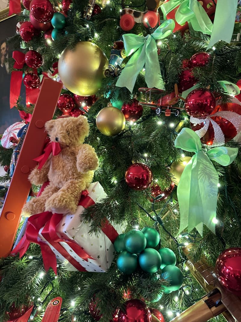 teddy bear and ribbons in Christmas tree with lights