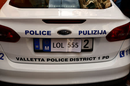 A sticker resembling a car registration plate is seen on a police car as civil society activists call on the police to question Maltese Economy Minister Chris Cardona, after some of the journalists from the Daphne Project initiative reported him as having met with one of the men accused of the murder of anti-corruption journalist Daphne Caruana Galizia, outside the police station in Valletta, Malta April 19, 2018. REUTERS/Darrin Zammit Lupi