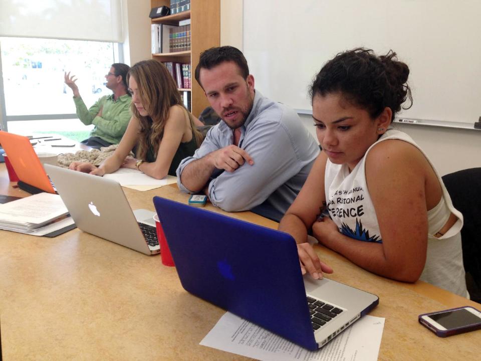 FILE - In this March 21, 2014 file photo, Anthony Rouzier, second right, helps Valentina Adarraga, 20, right, sign up for health insurance under the Affordable Care Act in Miami. Despite Florida Republicans' efforts to fight the Affordable Care Act at every turn, more than 440,000 Florida residents had been enrolled through the federal marketplace through the end of February. (AP Photo/Kelli Kennedy, File)