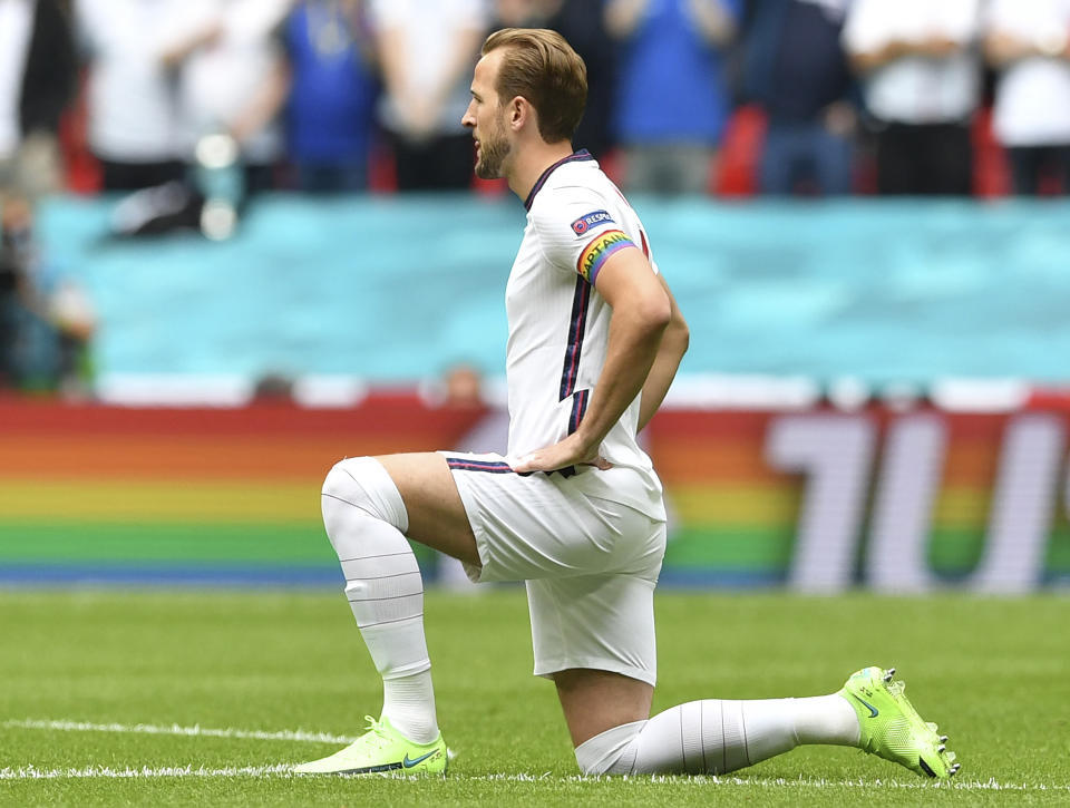 FILE - England's Harry Kane wears a rainbow armband as he takes the knee prior to the Euro 2020 soccer championship round of 16 match between England and Germany at Wembley Stadium in England. The captains of seven European nations will not wear anti-discrimination armbands in World Cup games after threats from FIFA to show yellow cards to the players. The seven soccer federations say "we can’t put our players in a position where they could face sporting sanctions.” (Justin Tallis, Pool Photo via AP)