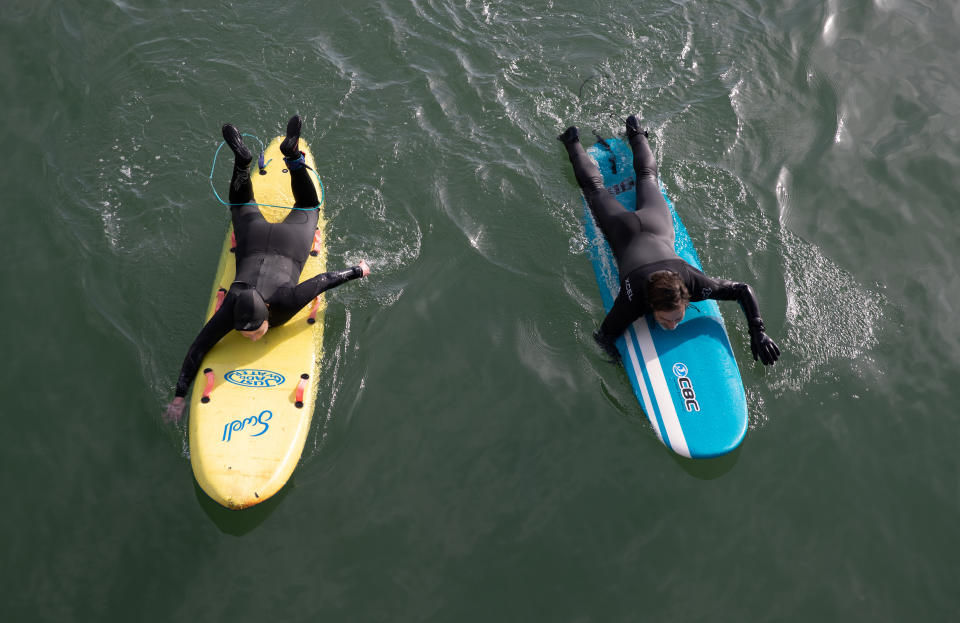 Two paddle boarders in the sea off of Boscombe beach in Dorset. Picture date: Tuesday March 30, 2021. Temperatures in parts of the UK are expected to be significantly warmer this week as families and friends are reunited and sporting activities are allowed to resume in England.