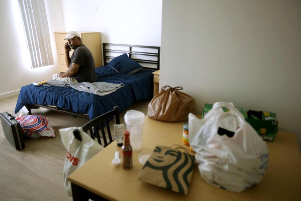 A man sits on his bed and reflects in his new apartment.