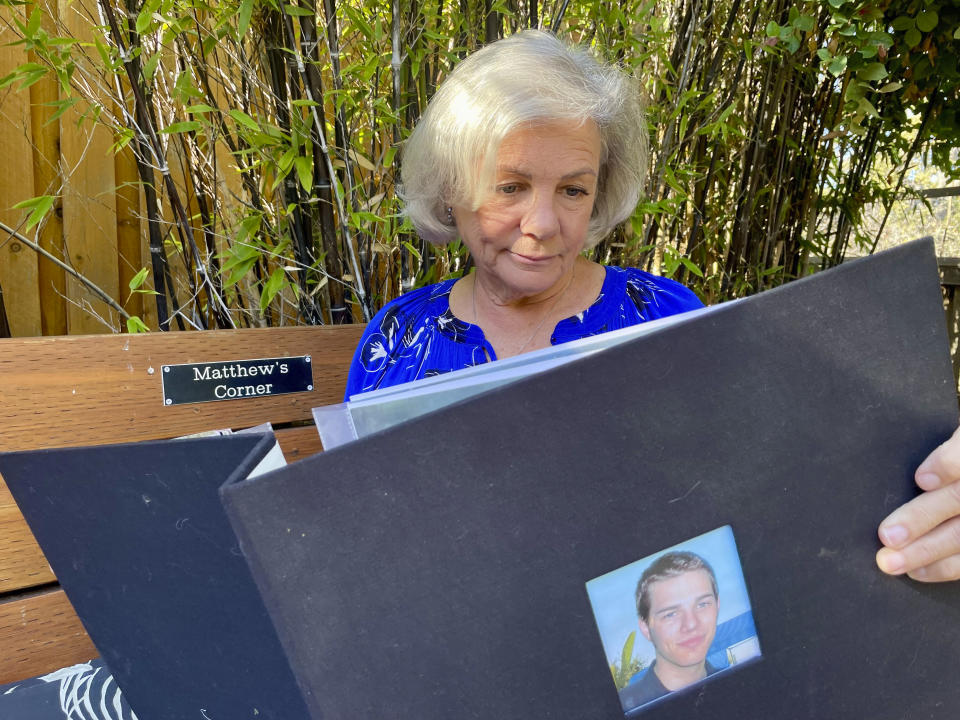 Dayna Witmer, looks over photos of her son Matthew at her home in Hercules, Calif., on Monday, Dec. 4, 2023. In 2007 Witmer's son committed suicide jumping from the Golden Gate Bridge. A suicide prevention barrier at the bridge in San Francisco is near completion more than a decade after officials approved it. (AP Photo/Haven Daley)